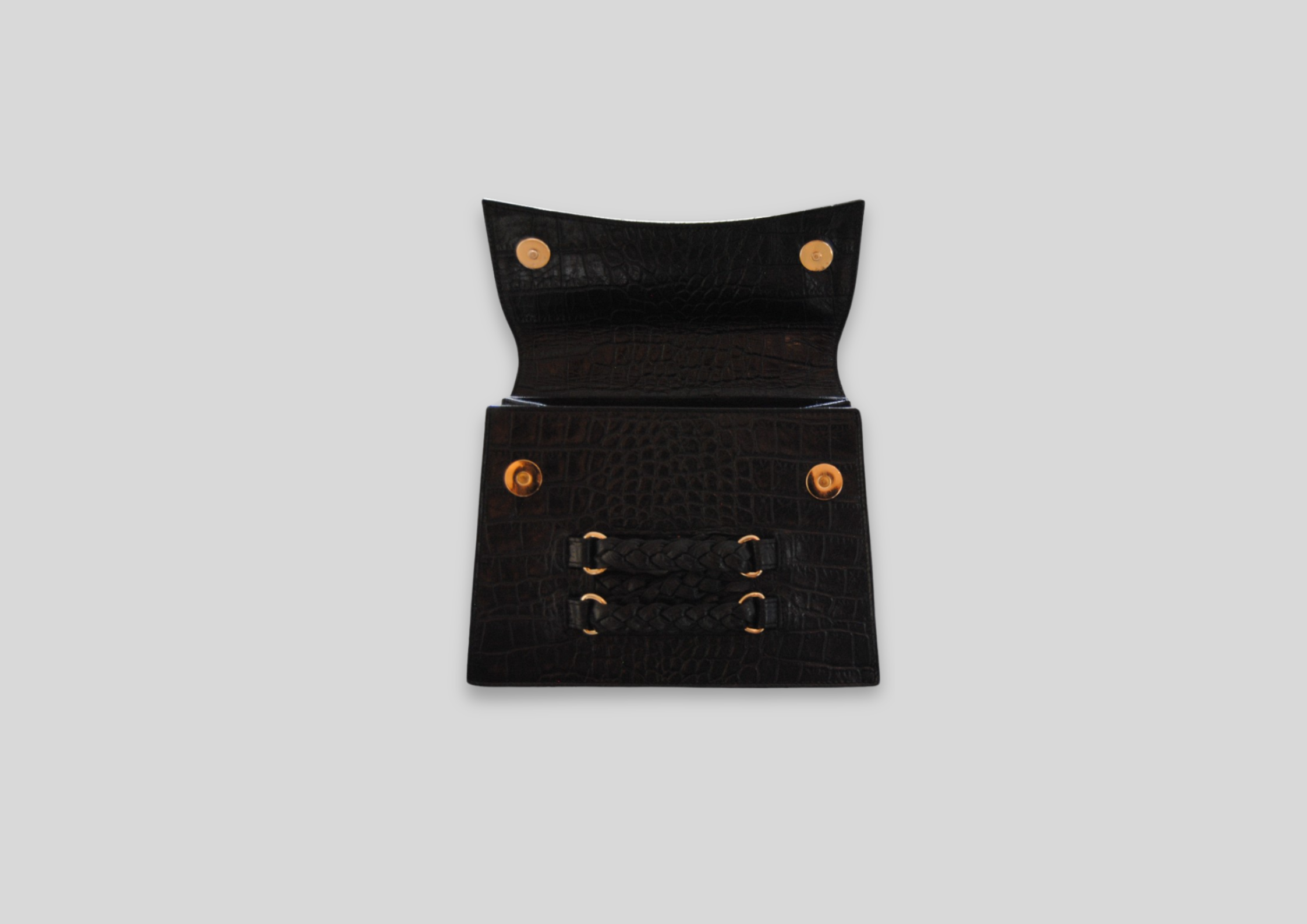 Elegant black leather clutch bag with braided detail and gold snap closures, showcasing luxury craftsmanship.