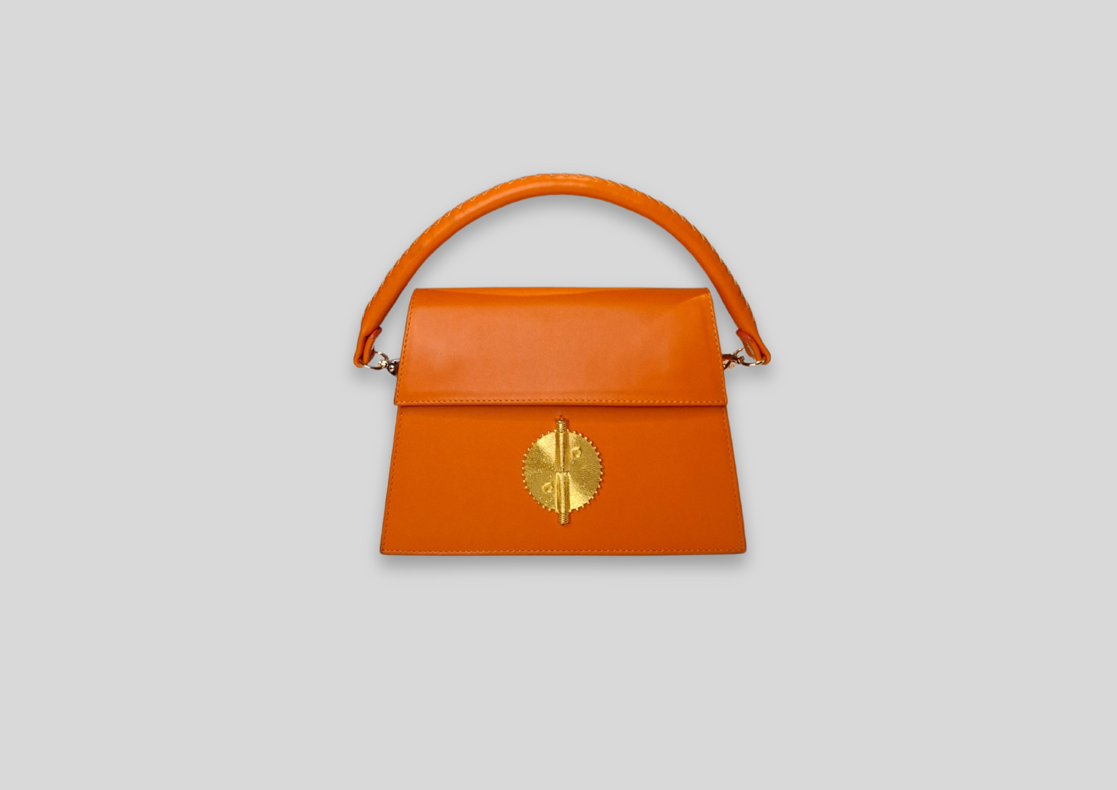 Malaika Bag in vibrant orange with intricate gold embellishment, perfect for special occasions and everyday elegance.